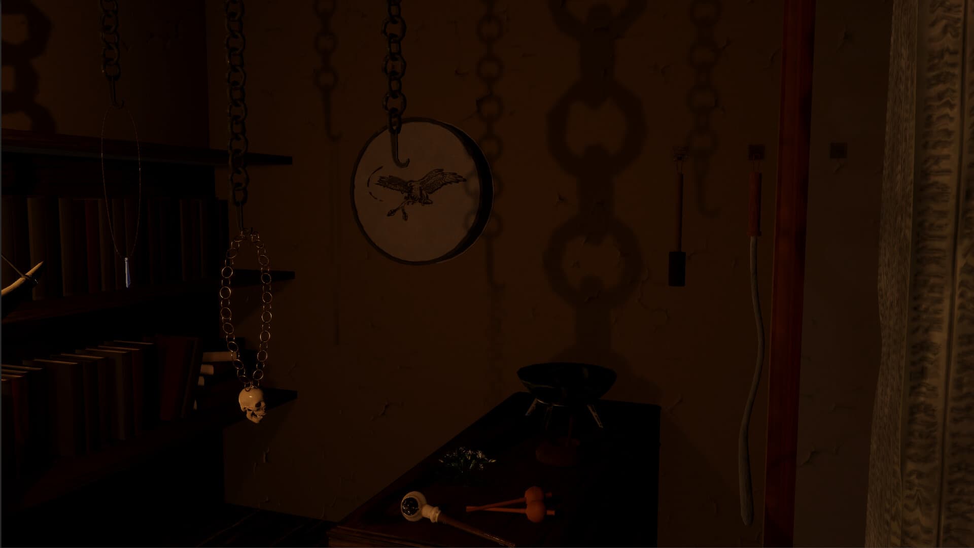 Karakam: hanging chains, a drum bearing a symbol and old objects in a dark room.